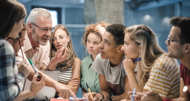 A group of learners around a laptop